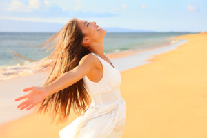 Free happy woman on beach enjoying nature. Natural beauty girl outdoor in freedom enjoyment concept. Mixed race Caucasian Asian girl posing on travel vacation holidays in dress.